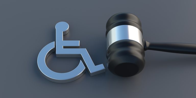 Disabled icon and judge gavel on gray background. Disability law for handicapped people concept