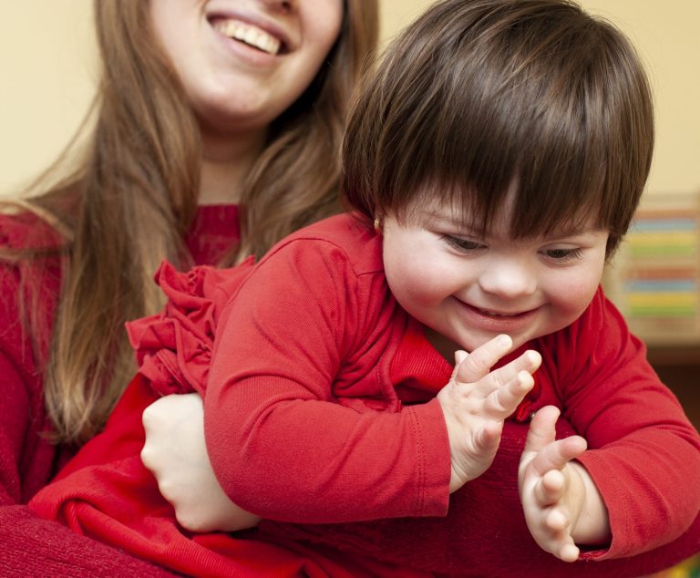 woman-holding-happy-child-with-down-syndrome